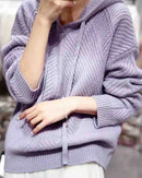  Woman lounging in the 100 % Wool Gentle Knitted Hoodie, 19.5-micron superfine Merino drapes like jersey—your cozy yet breathable 45-65 °F fall-through-spring essential.