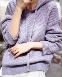  Woman lounging in the 100 % Wool Gentle Knitted Hoodie, 19.5-micron superfine Merino drapes like jersey—your cozy yet breathable 45-65 °F fall-through-spring essential.