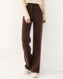 Woman commuting in 100 % wool knitted straight-leg pants, 19.5 micron superfine knit drapes like jersey—your polished yet cozy 45-65 °F fall-to-spring commuter layer.