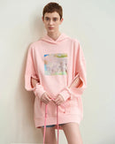 Street-shot of unisex hoodie splashed with surreal blue-green brushstrokes, oversized fit turns everyday fleece into walking gallery wall for fall-to-spring outfits.