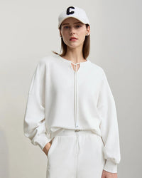Fashion-forward women's cotton sweatshirt with striking collision color splicing and decorative strap accents, relaxed loose fit long sleeve pullover perfect for spring casual wear and modern street style.