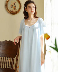 Woman drifting off in a cloud-white casual round-neck loose nightdress, airy 100 % cotton jersey and relaxed A-line cut keep you cool—your breathable staple for 70-85 °F summer nights 
