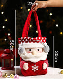 Child grinning beside red drawstring candy bag embroidered with Santa and reindeer, roomy enough for apples, cookies, and small toys .