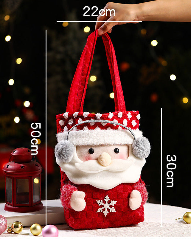 Child grinning beside red drawstring candy bag embroidered with Santa and reindeer, roomy enough for apples, cookies, and small toys .