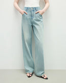Woman street-styling distressed high-waist straight jeans, sun-fade indigo wash and knee-slit rips give lived-in 90s attitude—92 % cotton / 6 % poly / 2 % elastane keeps structure while adding stretch for 60-75 °F spring-fall days.