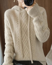 Woman lounging in the Drawstring Cashmere-Wool Blended Hoodie, 70 % cashmere / 30 % wool knit and relaxed drop-shoulders give cloud-soft warmth—your luxe yet breathable 55-70 °F cold-season essential.