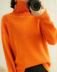 A 100% wool turtleneck sweater with a loose fit and dense knit, designed for soft warm comfort that layers easily from office to evening.
