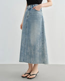 Woman brunching in a sand-beige high-waist slimming mid denim skirt, 90 % cotton / 10 % elastane hugs the waist and flares to midi length—your vintage-inspired staple for 60-75 °F spring-fall days.