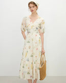 A breezy holiday-style dress with a feminine V-neck and an all-over vibrant flower print, perfect for summer vacations and garden parties.