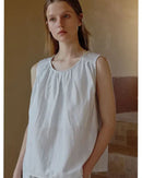 Woman relaxing in a pale-striped cotton-blend loungewear set, breathable jersey tee and drawstring shorts keep you cool on lazy summer mornings.