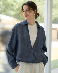Women’s retro “two-fakes” linen blouse in muted ocean-blue, deep V-neck and long sleeves, paired with crisp white cropped vest—effortless streetwear statement for spring city strolls or rooftop brunch selfies.