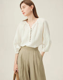 Woman brunching in a sand-beige linen three-quarter sleeve shirt, airy flax fibers and loose cut keep you cool—your effortless staple for 70–85 °F spring-summer days.