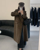 Woman crossing city bridge in camel long double-faced wool overcoat, single-button closure and side slits create fluid movement for winter commutes.