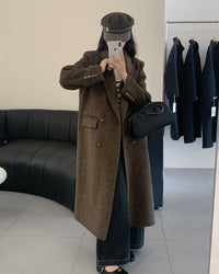 Woman crossing city bridge in camel long double-faced wool overcoat, single-button closure and side slits create fluid movement for winter commutes.