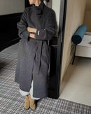 Side angle of model belted in max-length coat, wind-blocking flap front and brushed wool keep warmth without bulk on coldest days.