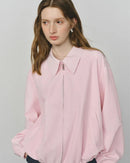 Woman styling a boxy cotton canvas jacket, loose fit and utility pockets give street-to-studio versatility for mild-weather days.