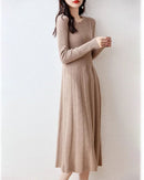 Woman posing in a Merino Wool Knitted Sweater Dress, 100 % superfine Merino rib drapes like jersey—your luxe yet breathable 60-75 °F spring-fall statement.