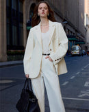 Woman layering a sand-beige notched-collar single-breasted blazer, tailored waist and two-button close elevate jeans or pencil skirts for spring office chic.