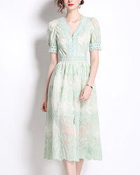 Model wearing light green lace puff sleeve midi dress with V neck and embroidered details, standing against white background, elegant spring summer style
