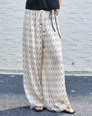  Elegant white linen tencel pants with elastic waistband and side pockets, showcasing a minimalist geometric design.