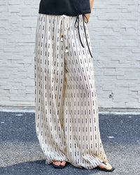  Elegant white linen tencel pants with elastic waistband and side pockets, showcasing a minimalist geometric design.
