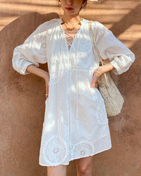 Elegant white cotton dress with floral embroidery, designed with a V-neck and A-line cut for a timeless French vintage aesthetic.