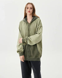 Woman layering an oversized cotton zipper washed hoodie, dropped shoulders and acid-wash finish give 90s street-style vibes—perfect lightweight layer for 60-75 °F spring-fall days.