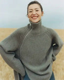 Oversized 100 % cashmere sweater, irregular diagonal zipper at high neck, dropped shoulders, ribbed cuffs, heather taupe—runway-ready winter layer for him or her.