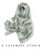 Woman looping a Pure Cashmere Hollow-Out Long Scarf, 19-micron Inner-Mongolia cashmere and open-work lattice knit give cloud-soft warmth—your wind-proof 35-55 °F fall-through-spring wrap that doubles as a blanket on flights.