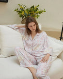 Soft rayon-satin pajama set with vibrant floral print, short-sleeve button-up top and elastic waist pants keep you cool and chic through warm summer nights.
