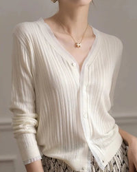 The lace detail on this cardigan is intentional and restrained — a single design element that transforms a classic knit silhouette into something genuinely memorable.