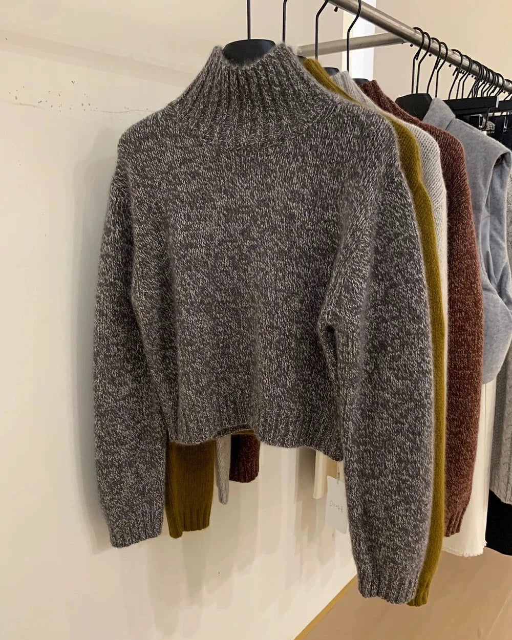 A short cashmere mock-neck sweater with mock neck, thick knit and loose fit, designed for a cozy winter layering look that pairs from sneakers to boots.