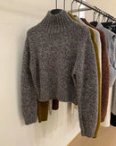 A short cashmere mock-neck sweater with mock neck, thick knit and loose fit, designed for a cozy winter layering look that pairs from sneakers to boots.