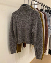 A short cashmere mock-neck sweater with mock neck, thick knit and loose fit, designed for a cozy winter layering look that pairs from sneakers to boots.