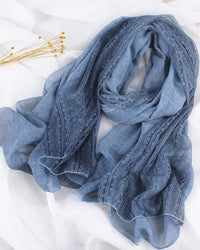 A thin linen-look shawl scarf with delicate lace trim and a 190x90cm cut, designed for soft drape and versatile layering in any season.