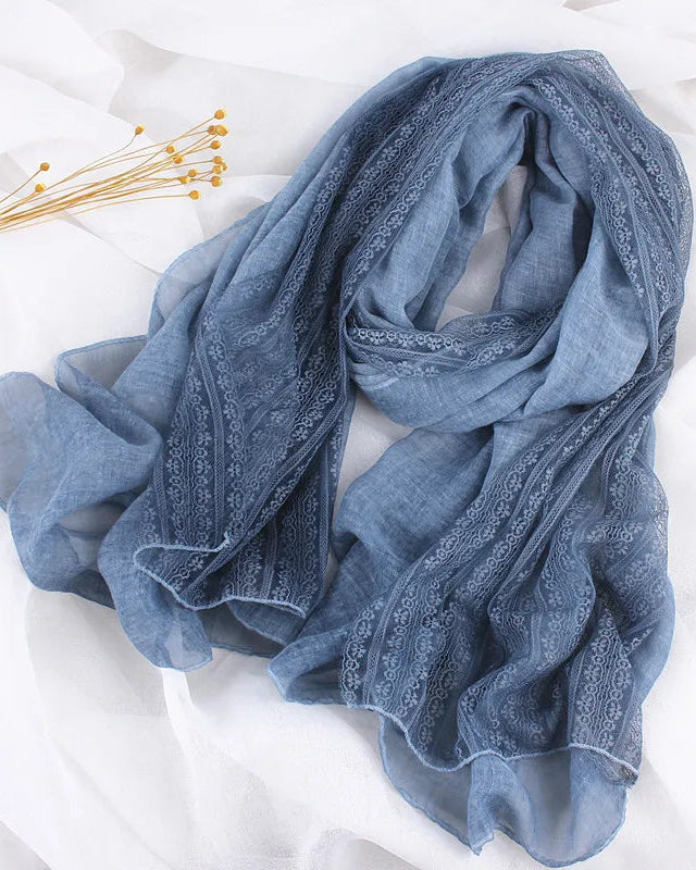 A thin linen-look shawl scarf with delicate lace trim and a 190x90cm cut, designed for soft drape and versatile layering in any season.
