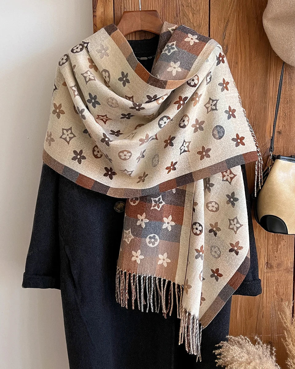 This printed shawl scarf carries the warmth of a blanket in the form of a refined accessory. 