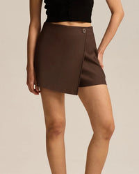 Women's asymmetric A-line mini skort featuring breathable polyester-nylon blend, an elastic waist, and button detail for modern summer office wear.