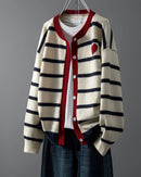 A tactile knit surface adds dimension, balanced by a simple round neckline and neat button fastening. 
