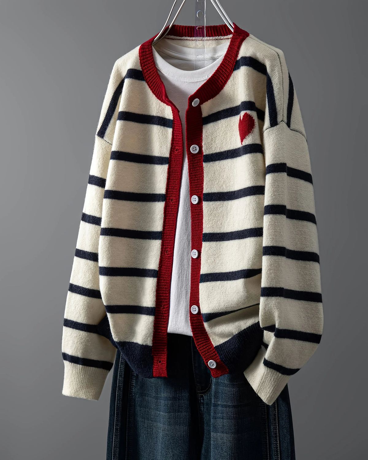 A tactile knit surface adds dimension, balanced by a simple round neckline and neat button fastening. 