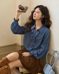 Women's blue ruffled placket denim shirt, featuring lyocell imitation-denim and a cinched waist for soft, breathable elegance from office desk to weekend brunch.