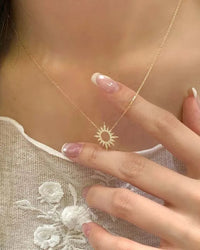 A delicate clavicle necklace featuring a hollow sunflower pendant with zircon crystals on a fine chain, secured with a lobster clasp for a radiant look.