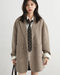 A wool-blend double-breasted midi overcoat featuring a turn-down collar, side pockets, and a relaxed fit for elegant autumn-winter wear.