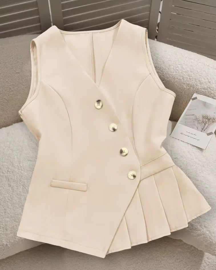 V-neck sleeveless peplum vest with asymmetric gold button closure, side pocket and pleated hem. Tailored polyester blend — polished office-to-casual style.