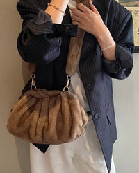 A ruched faux fur cloud shoulder bag with hasp closure, cell phone pocket and single strap, designed for a cozy winter look that moves from day to evening.