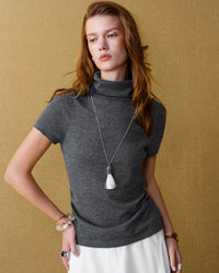 A wool-blend mock neck knit top with short sleeves and slight stretch, designed for an elegant office look that transitions from day to autumn evenings.