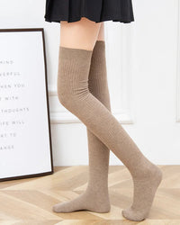 Ribbed wool over-knee stockings. Natural fiber warmth, soft knit texture, elegant thigh-high silhouette. Perfect for autumn styling. 
