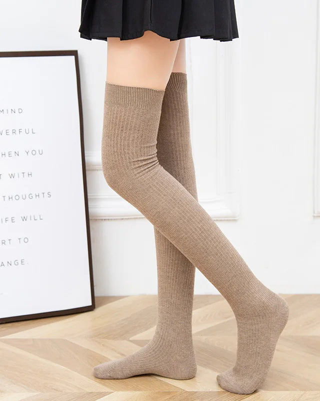 Ribbed wool over-knee stockings. Natural fiber warmth, soft knit texture, elegant thigh-high silhouette. Perfect for autumn styling. 