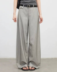 A pair of herringbone wide-leg suit trousers featuring a mid-rise waist, side pockets, and a zipper fly for a polished, versatile look.