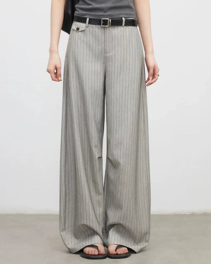 A pair of herringbone wide-leg suit trousers featuring a mid-rise waist, side pockets, and a zipper fly for a polished, versatile look.